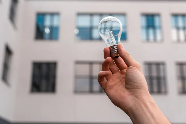 Cropped View Man Holding Light Bulb Building Background — Stock Photo, Image