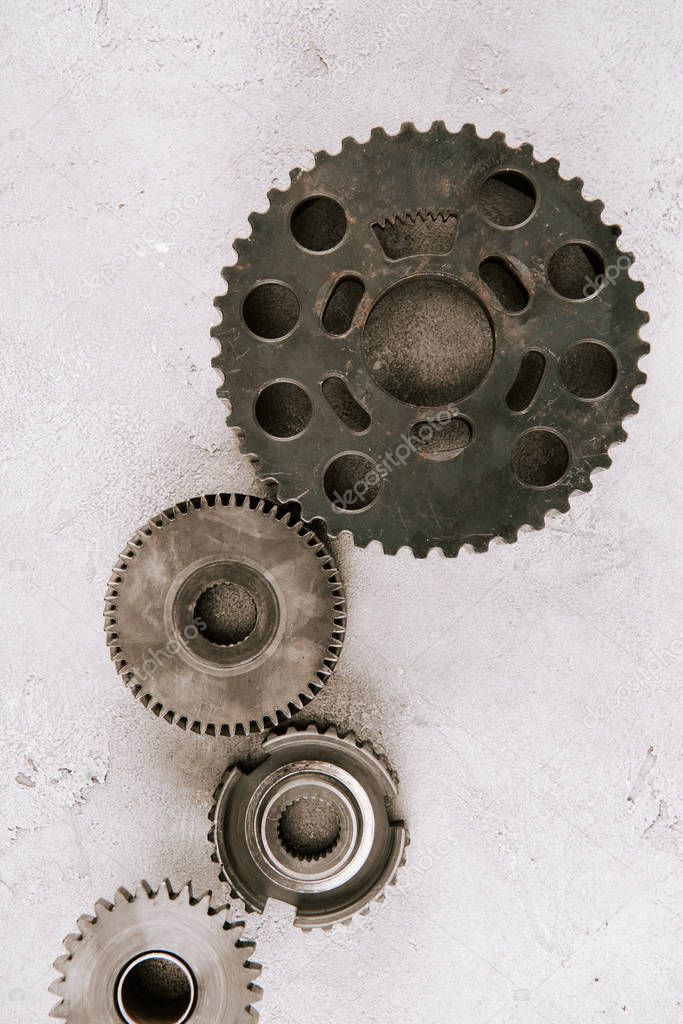 top view of aged metal round gears on grey background