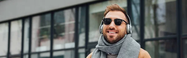 Foto Panorámica Del Hombre Sonriente Gafas Sol Auriculares Aire Libre — Foto de Stock