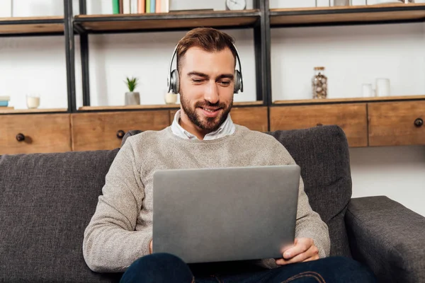 Smiling Man Headphones Using Laptop Sofa Living Room — Stock Photo, Image