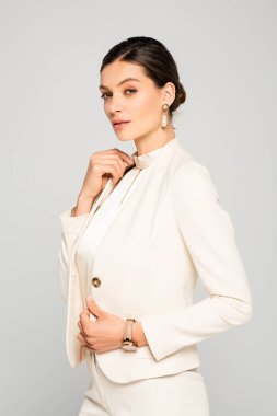 Beyaz takım elbiseli zarif, kendine güveni tam bir iş kadını.