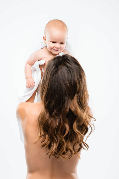 Back view of naked mother holding baby, isolated on white