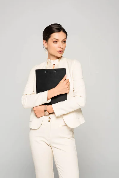 Mulher Negócios Confiante Elegante Terno Branco Segurando Prancheta Isolado Cinza — Fotografia de Stock