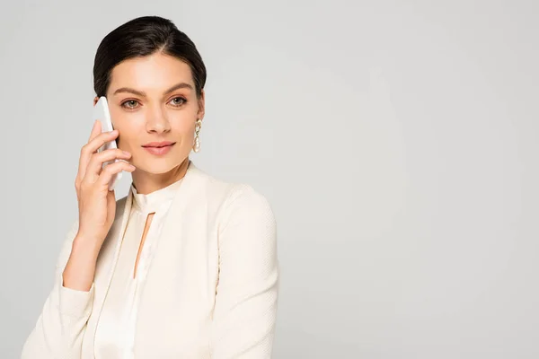 Krásná Usměvavá Podnikatelka Bílém Obleku Mluví Smartphonu Izolovaná Šedé — Stock fotografie