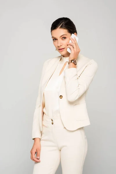 Όμορφη Κομψή Επιχειρηματίας Λευκό Κοστούμι Μιλάμε Για Smartphone Απομονώνονται Γκρι — Φωτογραφία Αρχείου