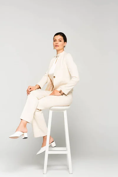 Attractive Confident Businesswoman White Suit Sitting Stool Grey — Stock Photo, Image