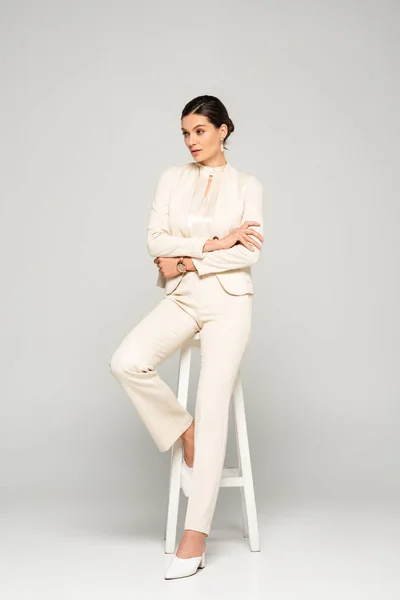 Elegant Confident Businesswoman White Suit Sitting Stool Grey — Stock Photo, Image