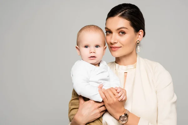 Bela Mulher Negócios Feliz Com Pouco Bebê Mãos Isolado Cinza — Fotografia de Stock