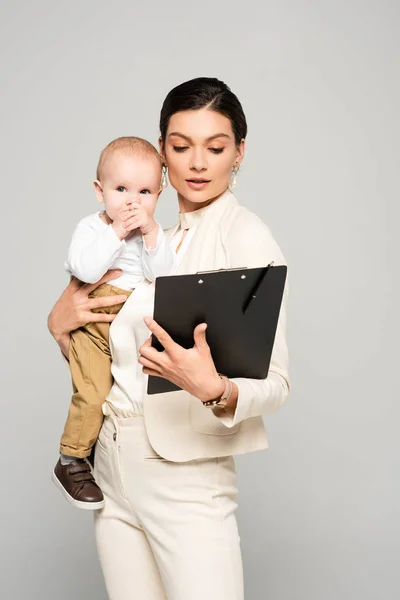 Jong Zakenvrouw Met Baby Jongen Handen Werken Met Klembord Geïsoleerd — Stockfoto