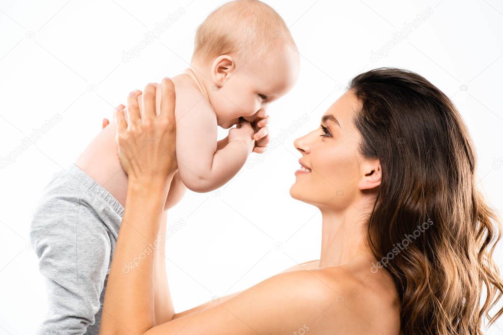 portrait of nude smiling mother looking at baby, isolated on white