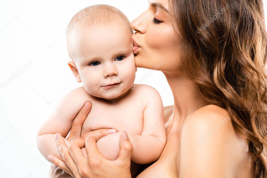 portrait of nude mother kissing adorable baby, isolated on white