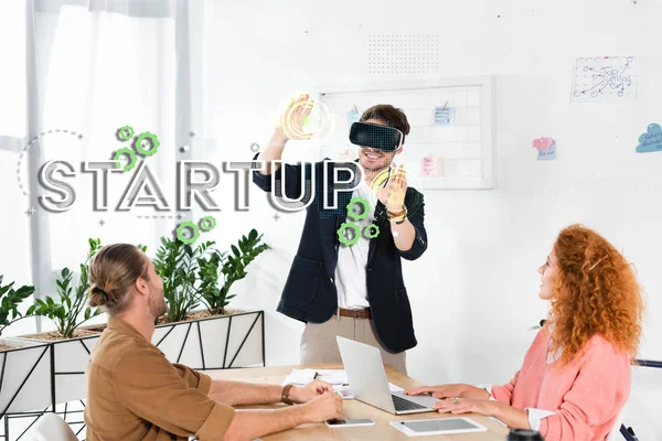 Glimlachende Zakenman Met Headset Gebaren Kantoor Buurt Van Collega Startup — Stockfoto