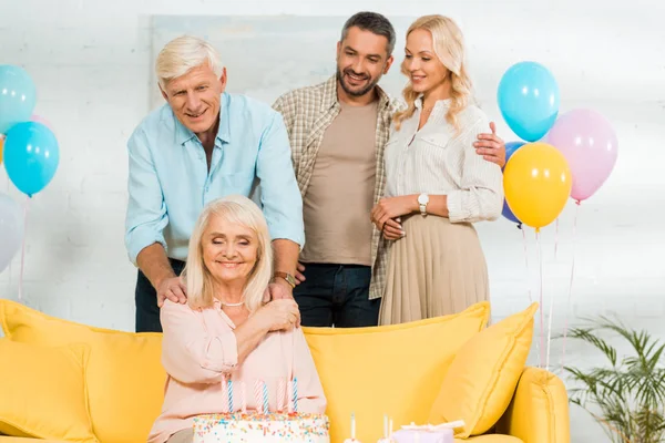 Gelukkig Senior Vrouw Zitten Gele Bank Buurt Van Verjaardagstaart Glimlachende — Stockfoto