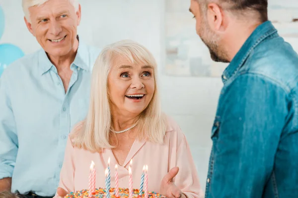 Glad Senior Kvinna Håller Födelsedagstårta När Står Nära Make Och — Stockfoto