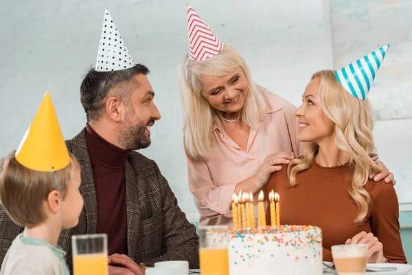 Sonriente Mujer Mayor Tocando Hombros Mujer Feliz Sentada Cerca Pastel — Foto de Stock