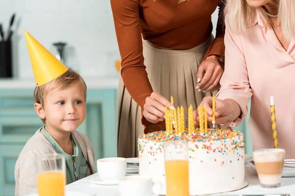 Menino Bonito Boné Festa Olhando Para Mãe Avó Colocando Velas — Fotografia de Stock