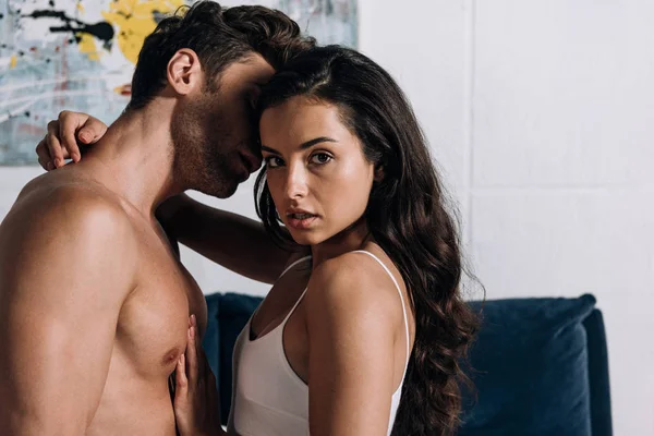 Tişörtsüz erkek arkadaşıyla kucaklaşırken kameraya bakan baştan çıkarıcı kız 