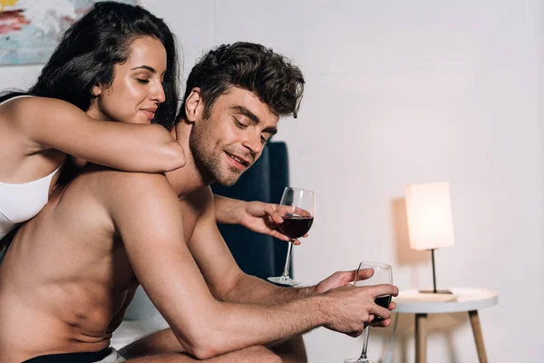 Mutlu Genç Çift Yatak Odasında Kırmızı Şarap Bardakları Tutuyor — Stok fotoğraf