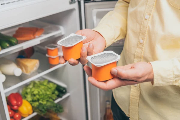 Levágott Kilátás Férfi Gazdaság Joghurt Közelében Nyitott Hűtőszekrény Tele Étellel — Stock Fotó