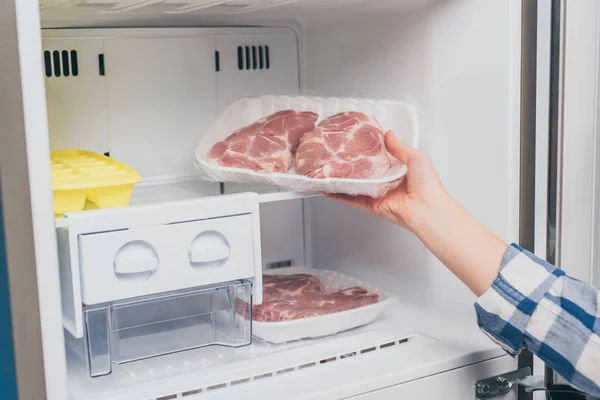 Vista Ritagliata Della Donna Che Estrae Carne Congelata Dal Congelatore — Foto Stock