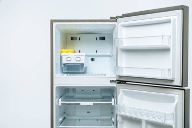 empty open fridge and freezer isolated on white clipart