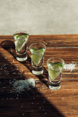 Taze tekila limonlu ve güneş ışığında ahşap yüzeyde tuz.