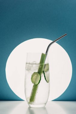 Salatalık dilimli taze limonata mavi arka planda kereviz ve saman.