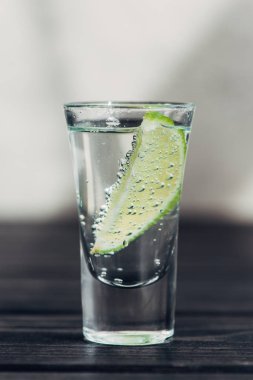 Ahşap yüzeyde limonlu taze tekila manzarası.