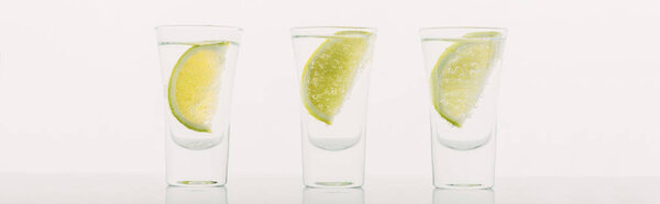 fresh tequila with lime in row isolated on white, panoramic shot