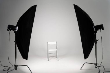 White chair with studio light on grey background clipart