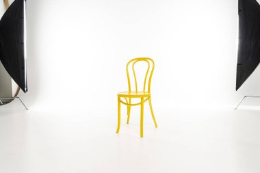 Yellow chair with studio light on white background clipart