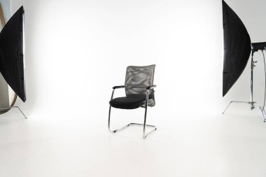 Black modern chair with studio light on white background clipart