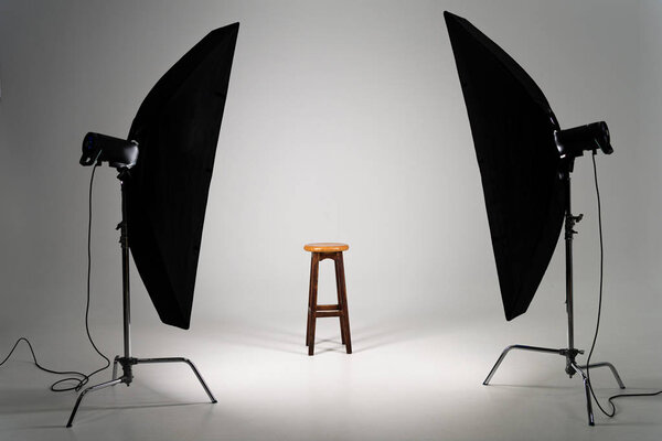 Wooden stool with studio light on grey background