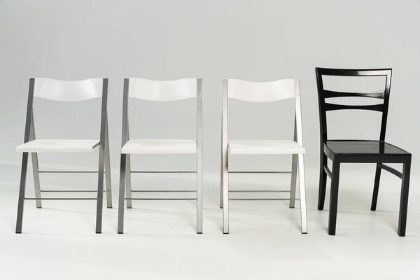 Modern white and black chairs on grey background