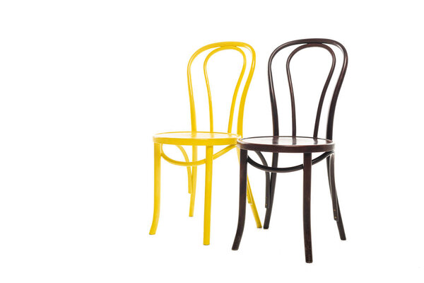 Коричневые и желтые современные стулья изолированы на белом
