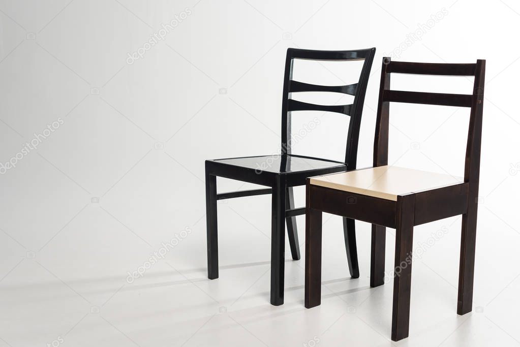 Two modern wooden chairs on grey background