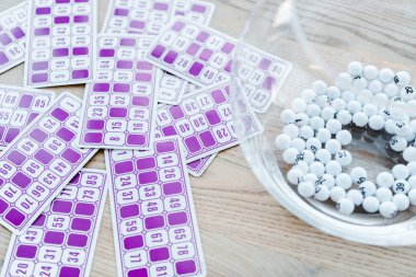 purple lottery tickets with numbers near bowl with balls  clipart