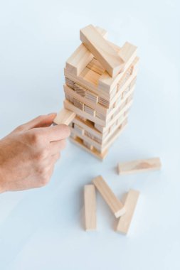 KYIV, UKRAINE - NOVEMBER 22, 2019: cropped view of man playing blocks wood game isolated on white  clipart