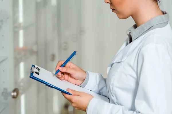 Vista Ritagliata Del Farmacista Femminile Con Appunti Accanto Alla Vetrina — Foto Stock