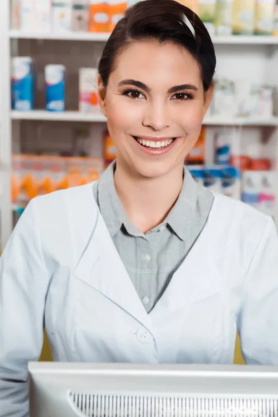 Atractivo Farmacéutico Sonriendo Cámara Con Medicamentos Los Estantes Fondo —  Fotos de Stock