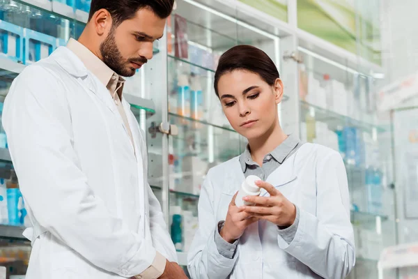 Vista Bajo Ángulo Del Farmacéutico Mirando Frasco Con Pastillas Farmacia — Foto de Stock