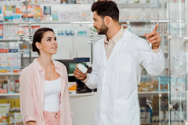 Droguista Sosteniendo Frasco Pastillas Señalando Escaparate Cliente — Foto de Stock