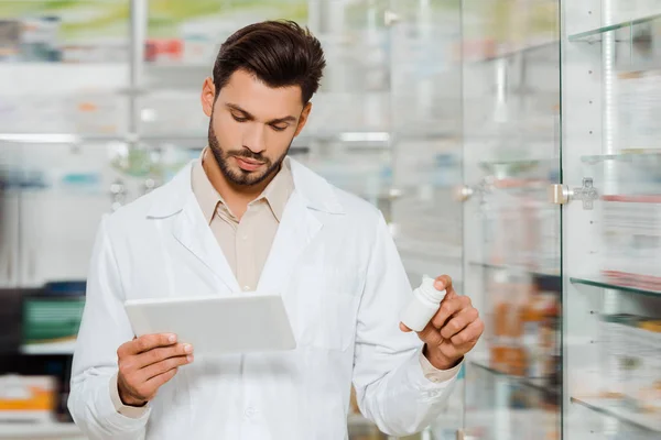 Bello Farmacista Che Utilizza Tablet Digitale Mentre Tiene Pillole Farmacia — Foto Stock