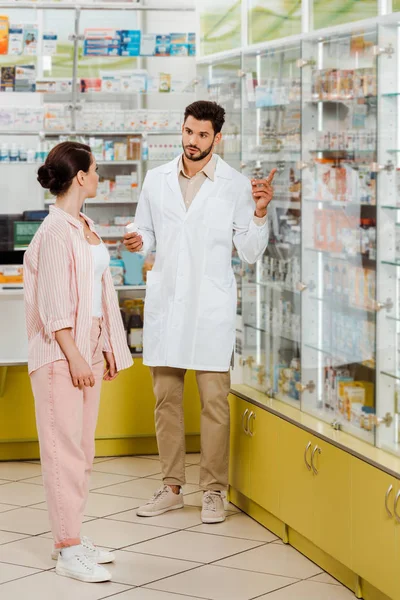 Farmacéutico Sosteniendo Medicamento Señalando Escaparate Farmacia Cliente —  Fotos de Stock