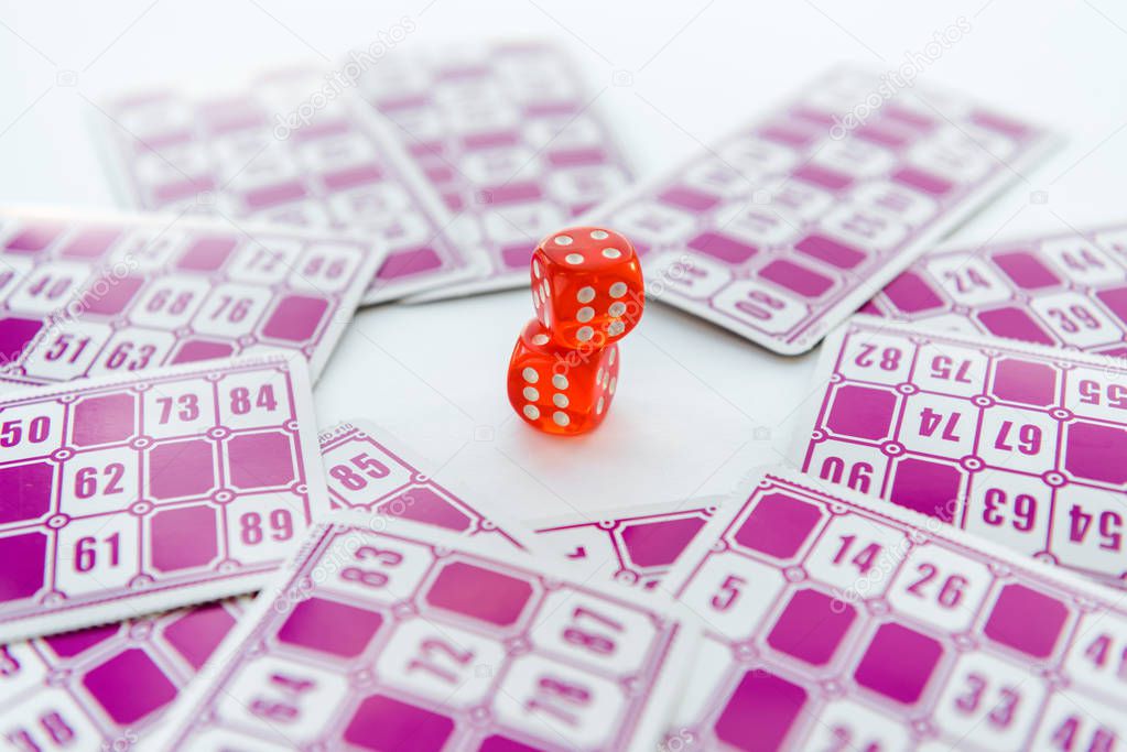 selective focus of red dice near lottery tickets isolated on white 