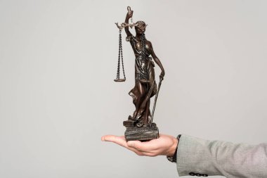 Onları tutan avukatın kısmi görüntüsü gri üzerine izole edilmiş bir heykel.