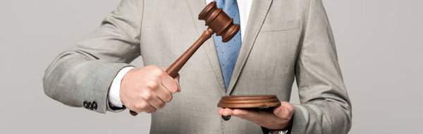 частичный взгляд судьи, держащего молоток изолированным на сером, панорамный снимок
