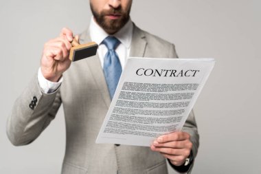cropped view of lawyer putting stamp on contract isolated on grey clipart