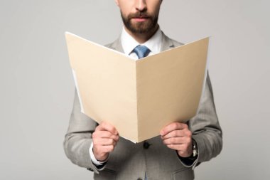Gri üzerine izole edilmiş kağıt klasörü tutan işadamlarının kısmi görünümü