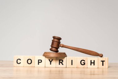 Tahta küplerin üzerindeki tokmak. Gri masa üzerinde kelime telif hakkı.